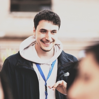 Photo showing Luca Pagliaro with a badge during a conference